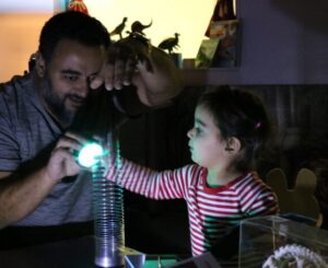 Man and small child doing science activity with Slinky